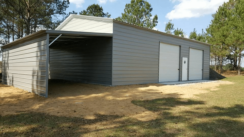 A grey steel building with a single door and garage doors on either side, as well as a lean-to on the left side