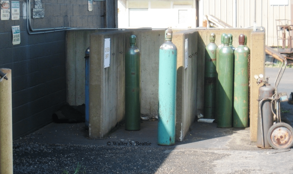 Gas cylinders sitting outside of a metal building